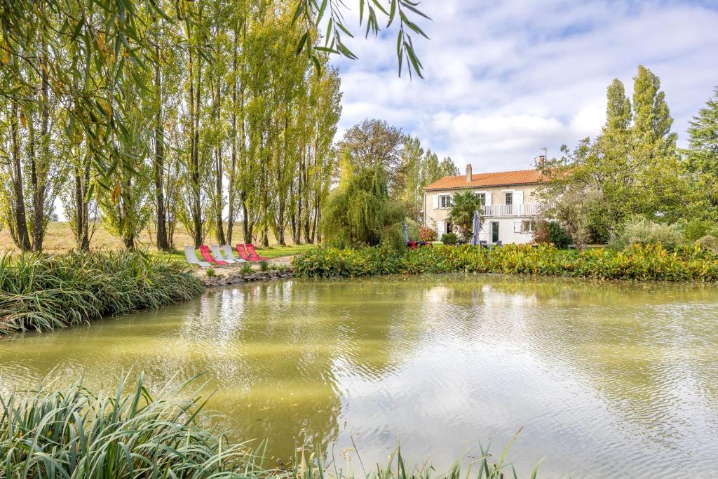 a house and a pond in front of a house at Chambres d'hôtes Le Boiziller in Saint-Michel-Mont-Mercure