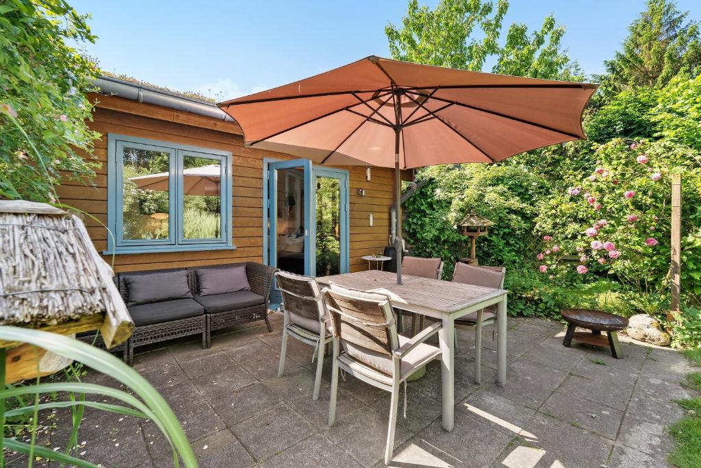 a patio with a table and an umbrella at Ferienhaus Dollrott in Süderbrarup