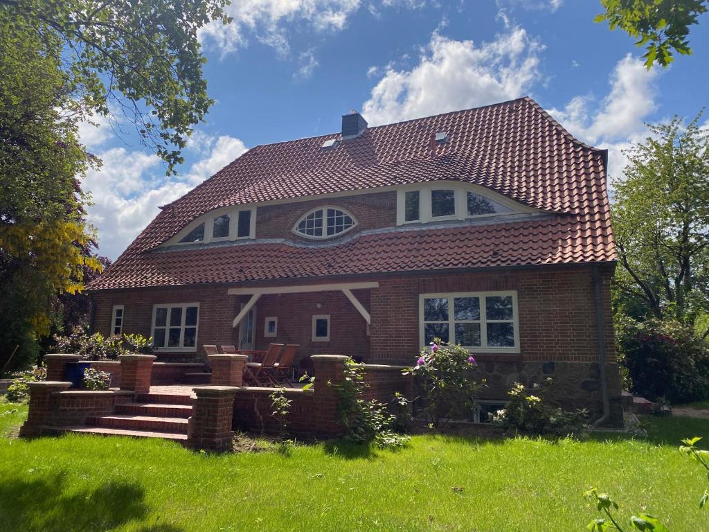 a brick house with a red roof at Große Atelierwohnung Barrierefrei in Meezen
