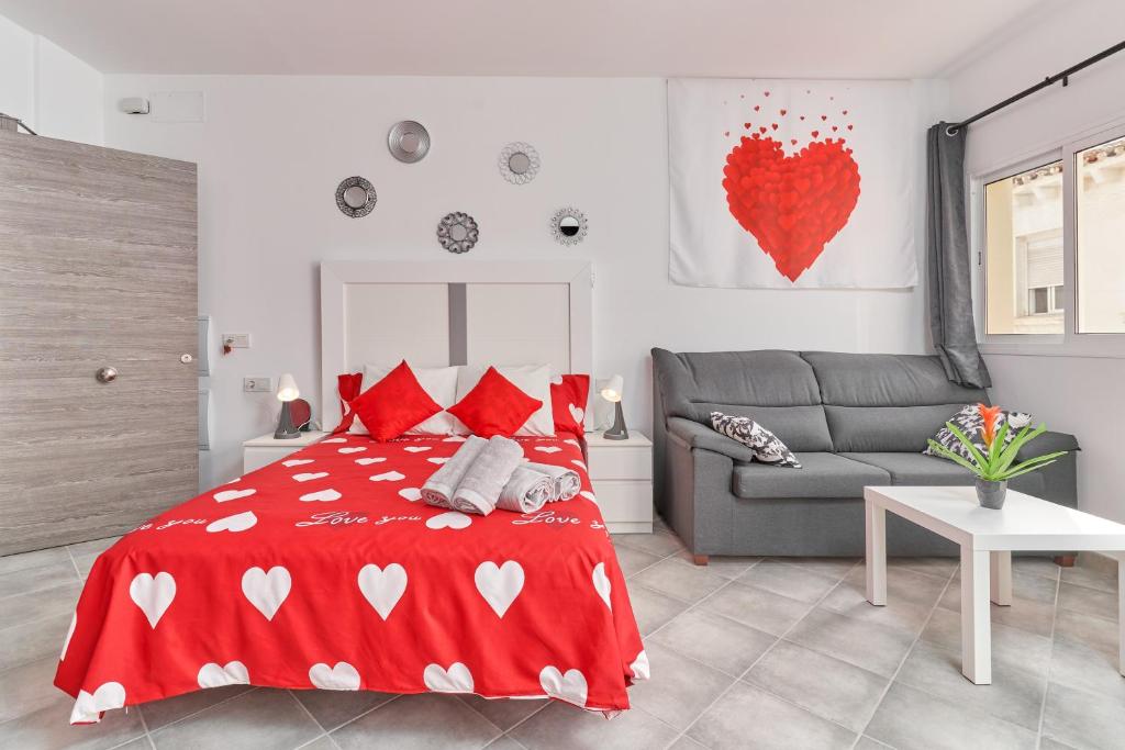 a bedroom with a red bed and a couch at Nerja Boutique 101 Deluxe in Nerja