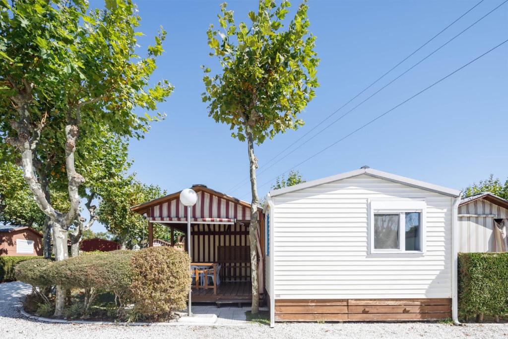 a small white shed with a table in a yard at Bungalow E in Pontevedra