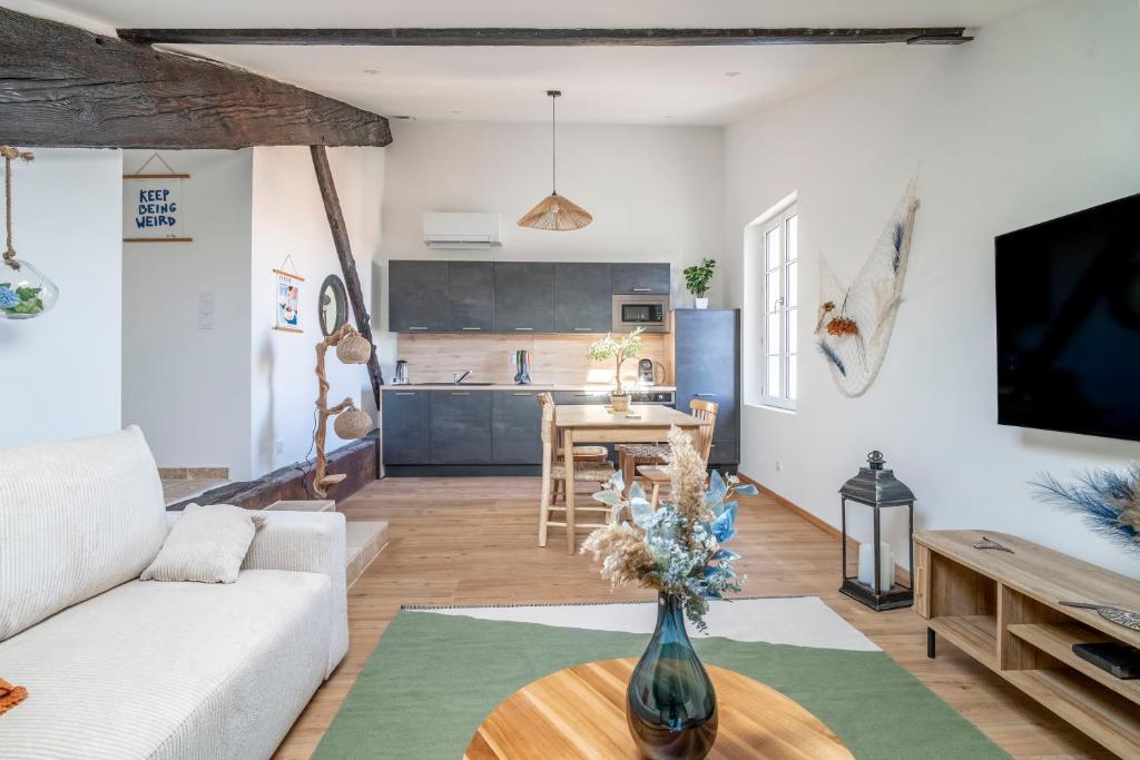 a living room with a couch and a table at Le Somail - Louis 14 in Ginestas