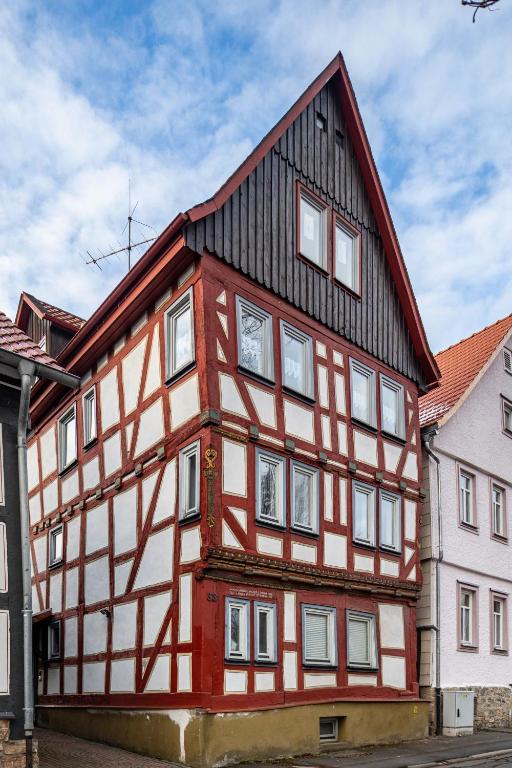 a red and white building with a black roof at Ferienwohnung Altstadtblick in Alsfeld
