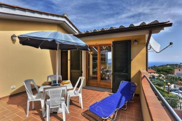 a patio with a table and chairs and an umbrella at Casa Consuelo App. 2 (trilocale) in Capoliveri