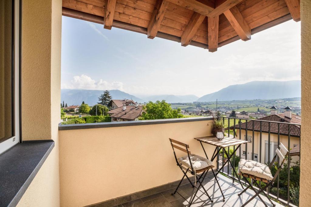 a balcony with two chairs and a table at Meine Bleibe Apartment Olive in Appiano sulla Strada del Vino
