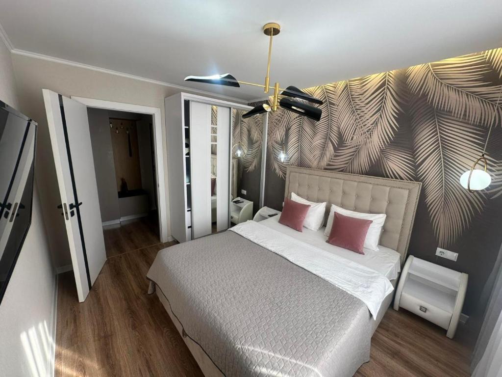 a bedroom with a large bed with two pink pillows at Sweethome Riscani in Chişinău
