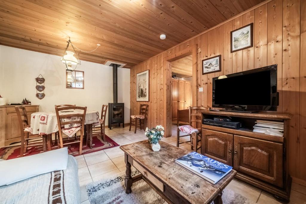 サン・ジャン・ドルプにあるChalet Ermenaのテレビとテーブルのあるリビングルーム