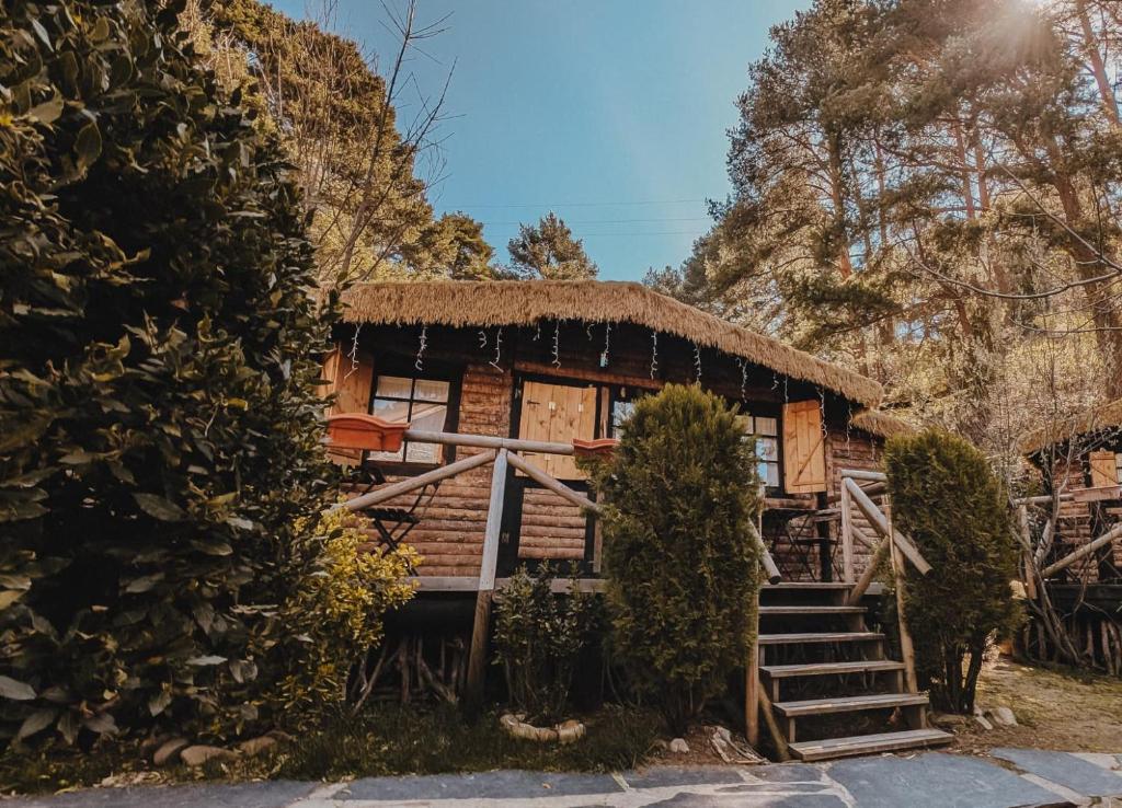 a log cabin with a thatched roof at La Posada Cercedilla in Cercedilla