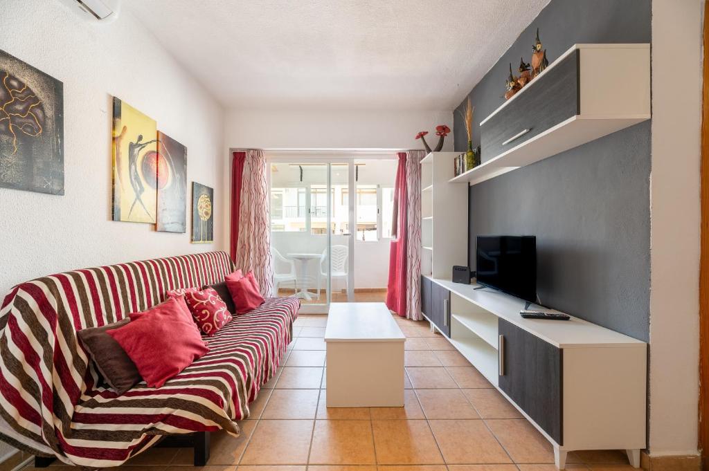 a living room with a couch and a television at Apartamento Trilo 24 in Es Pujols