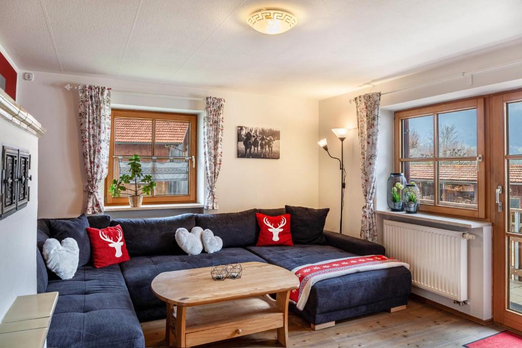 a living room with a blue couch and a table at Ferienwohnung Mair - Bergblick in Halblech
