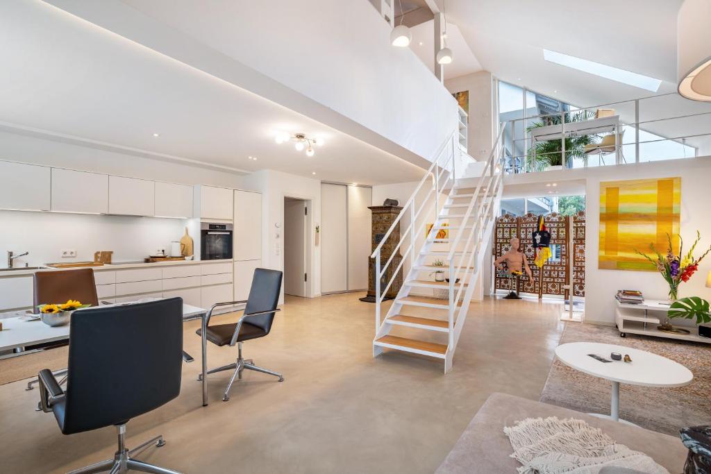 a living room with a staircase and a kitchen at Architektenhaus Baden mit Studio in Weier