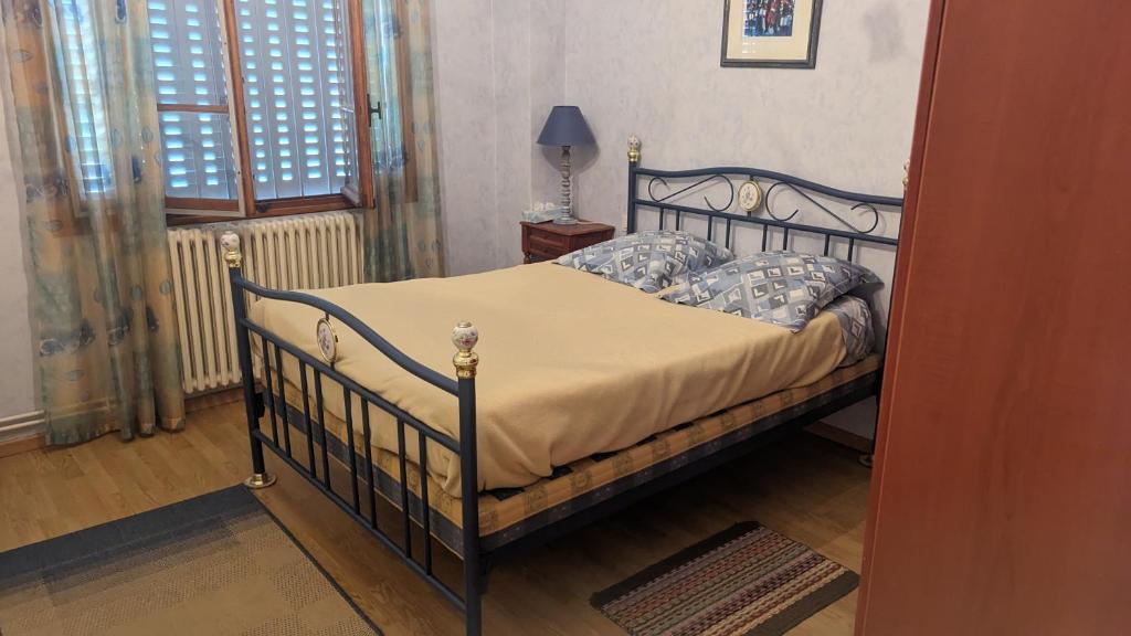 a bedroom with a bed and a lamp and a window at Appartement rochenoir in Saint-Jean-de-Maurienne