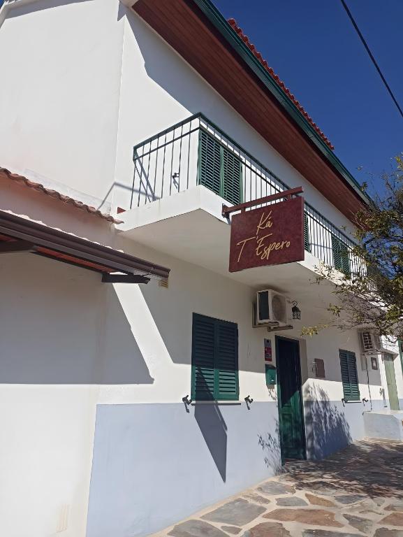 a white building with a balcony and a door at Ká T'Espero in Penha Garcia