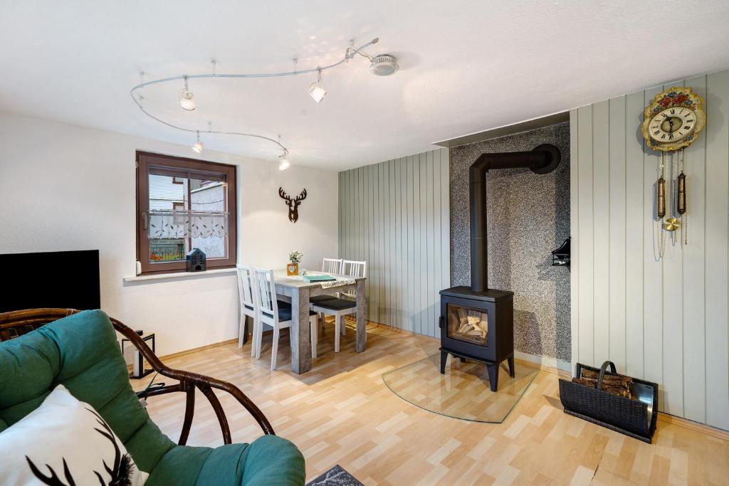 a living room with a fireplace and a dining room at Ferienwohnung im Salzgässle in Schonach