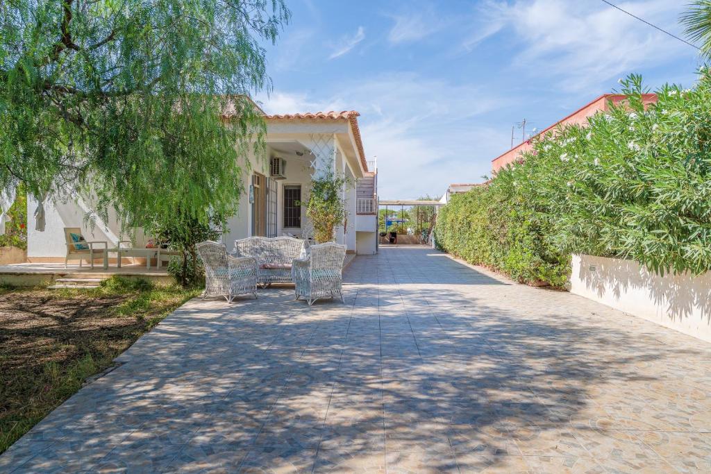 a walkway leading to a house with chairs and trees at Villa Amore - San Lorenzo in Reitani