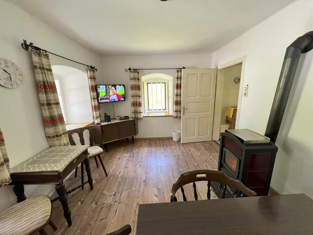 a living room with a table and chairs and a stove at Ferienhaus Maierhofer in Fischbach