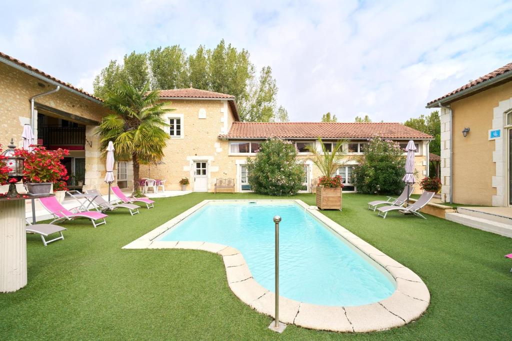 a swimming pool in a yard with chairs and a house at Chambres d'hôtes Le Pré Fleuri in Saint-Sulpice-de-Roumagnac