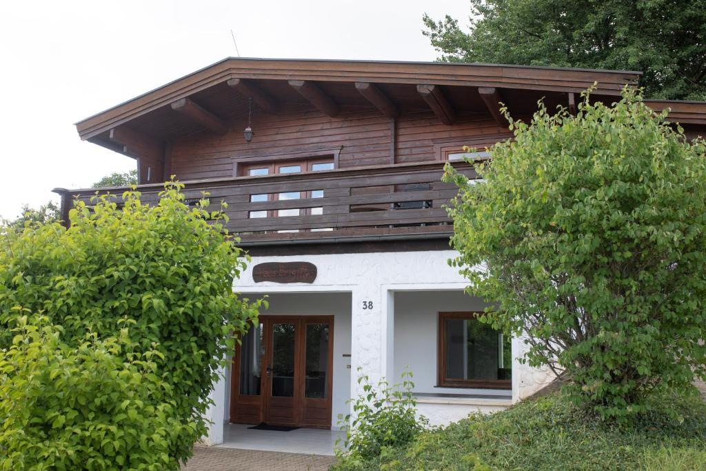a white house with a wooden roof at Gemütliches Blockhaus im Harz in Bad Sachsa