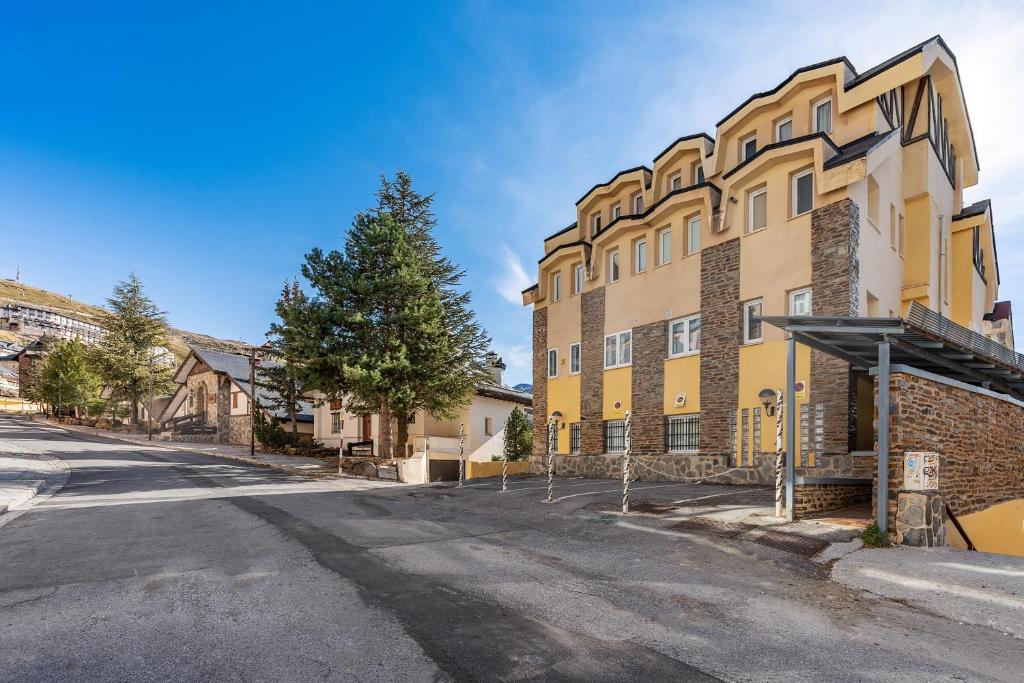 an empty street in front of a yellow building at Estudio bsg Sierra Nevada in Sierra Nevada