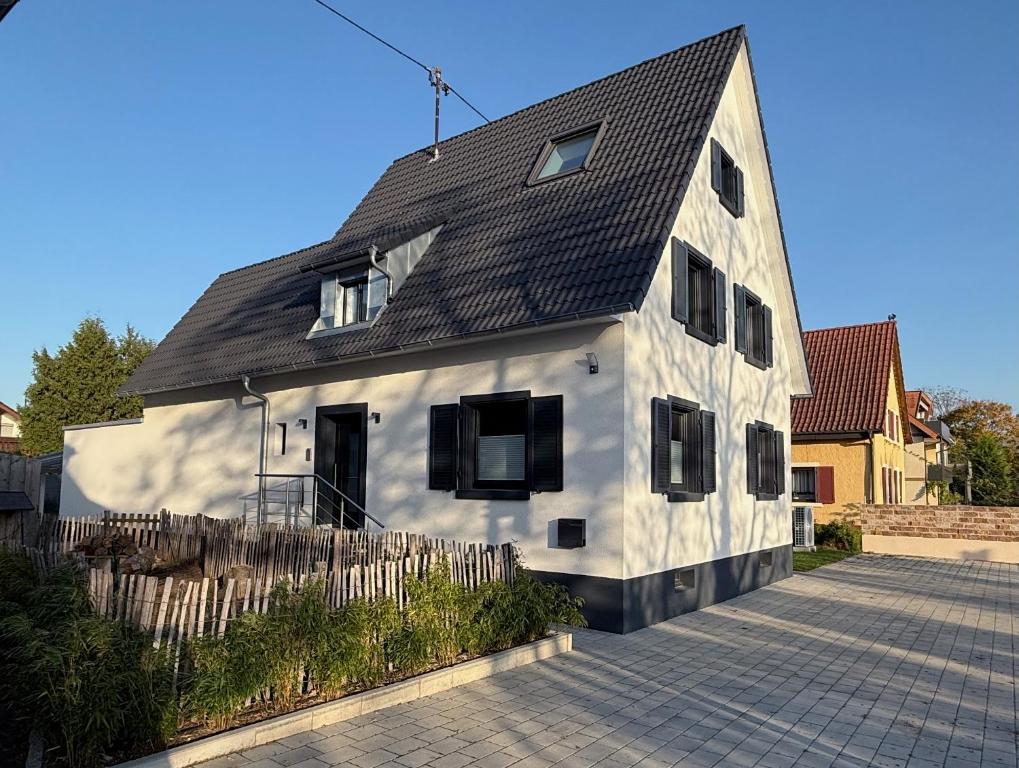 a white house with a black roof at Hq16 - Modernes Ferienhaus in Neuenburg am Rhein