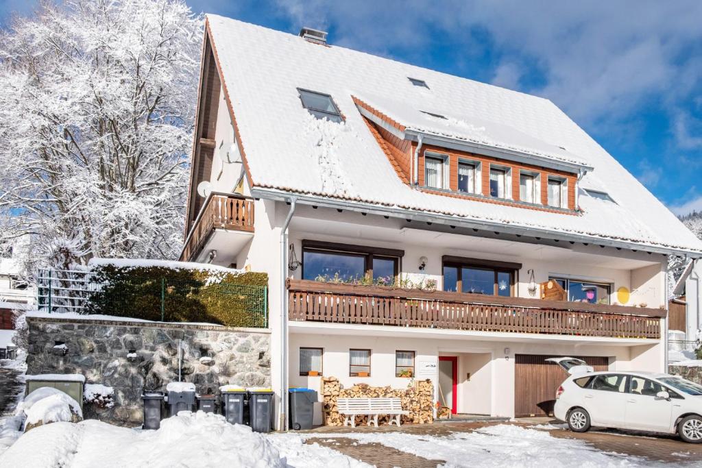 a house in the snow with a car parked in front at Haus Doktor Saeltzer in Lenzkirch