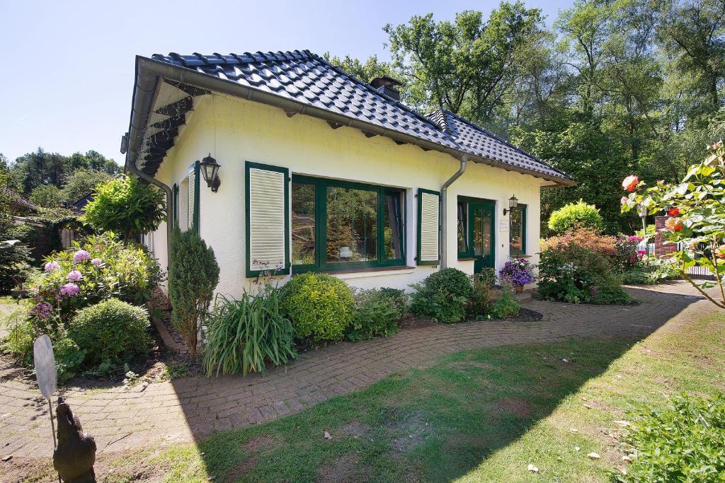 a small white house with a brick driveway at Im grünen Winkel in Brüggen
