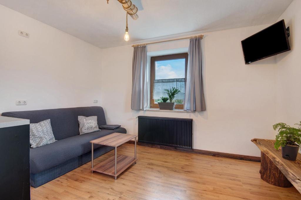 a living room with a blue couch and a window at Ferienhäusl in Eschlkam