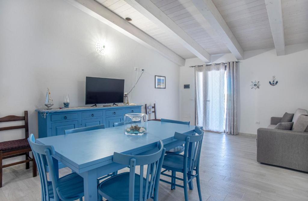 a living room with a blue table and chairs at Prima Luce in SantʼAnna Arresi