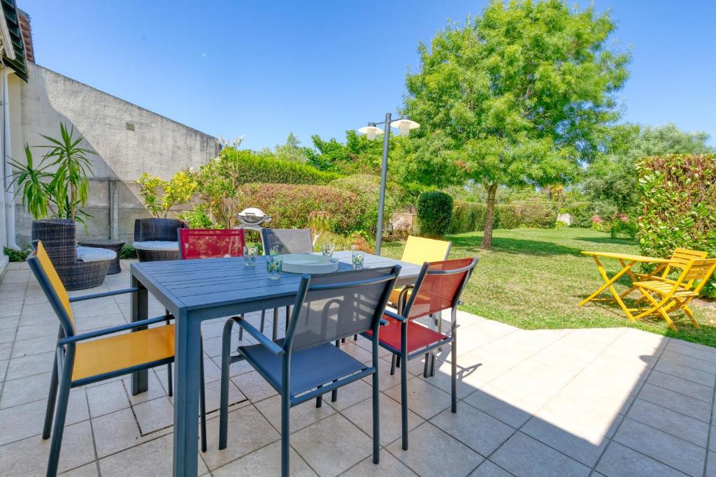 a blue table and chairs on a patio at Maison Ker Hélène sur grand jardin in Guérande
