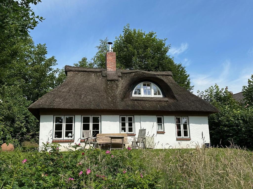 an old house with a thatched roof with a bench at Kate unter Reet im Grünen in Buchholz