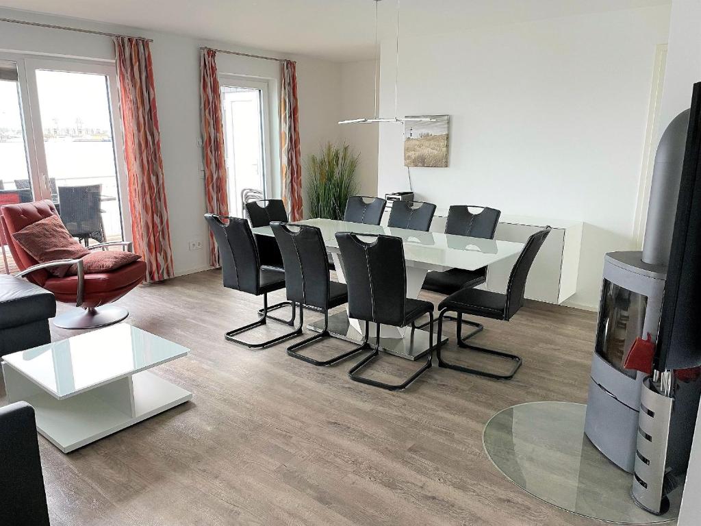 a living room with a dining room table and chairs at Lootsen Hus by Seeblick Ferien in Olpenitz