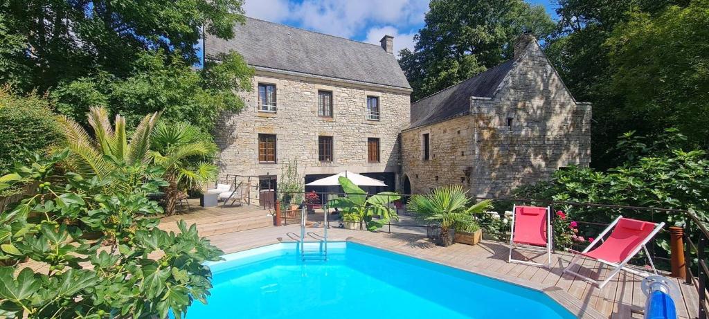 a house with a swimming pool in front of a building at Le Moulin De Lesnevé in Saint-Avé