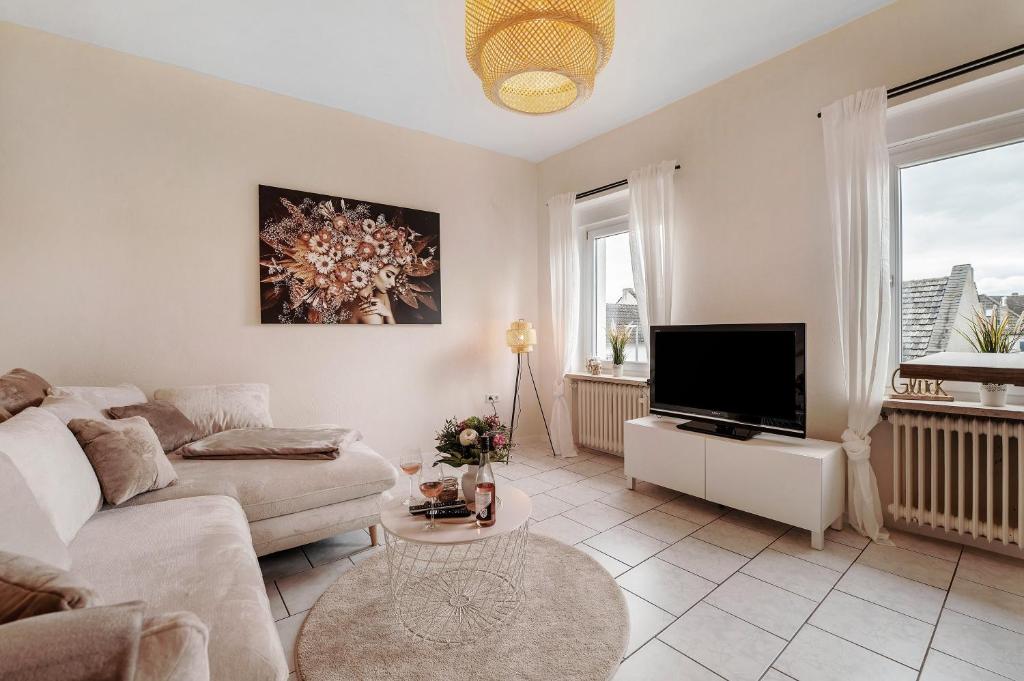 a living room with a couch and a flat screen tv at Auszeit am Schloss in Geisenheim