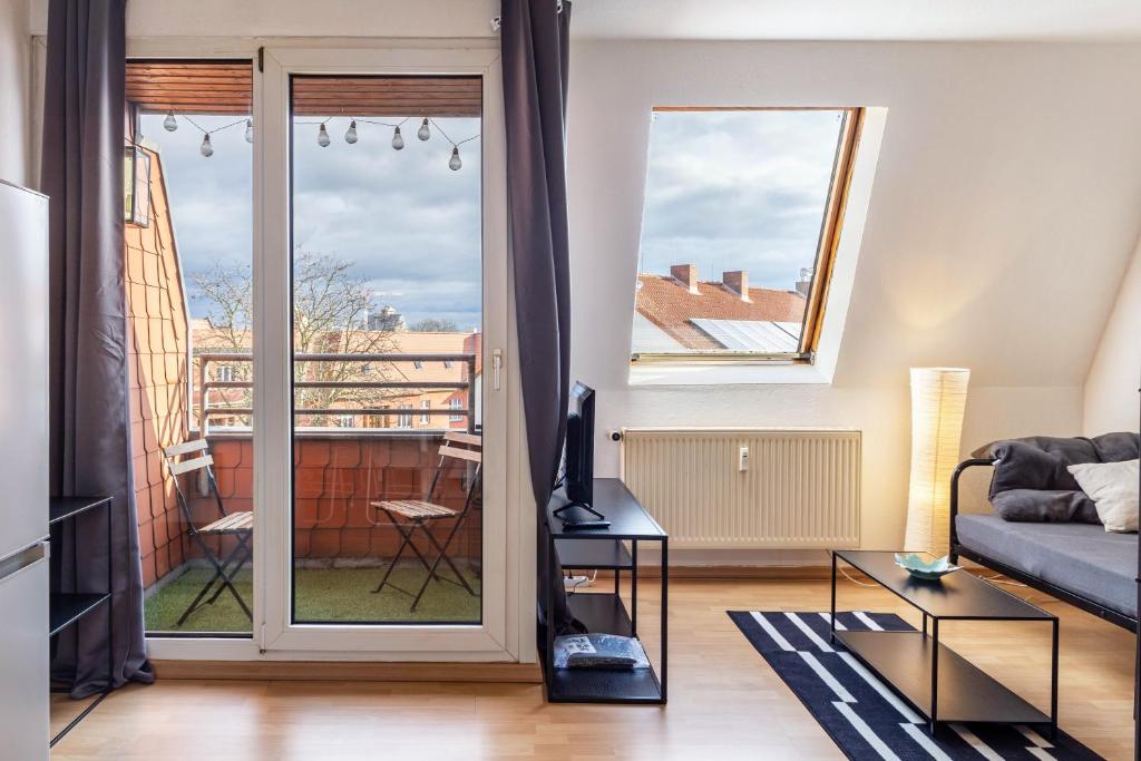 a living room with a couch and a balcony at Apartment Magdeburg in Magdeburg