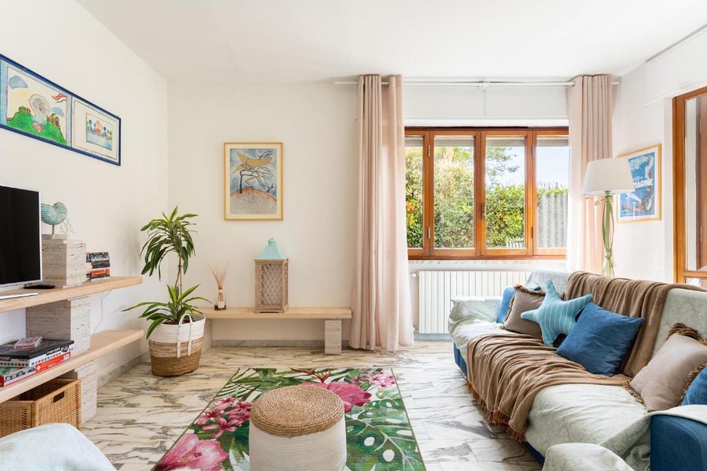 a living room with a couch and a tv at Villa Le Maree di Tonfano in Pietrasanta