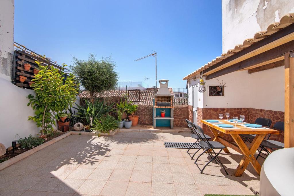 a patio with a wooden table and chairs at Casa Terracota in Silves