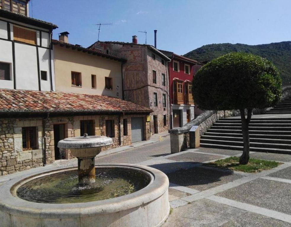 a fountain in the middle of a street with buildings at Juderia I in Oña