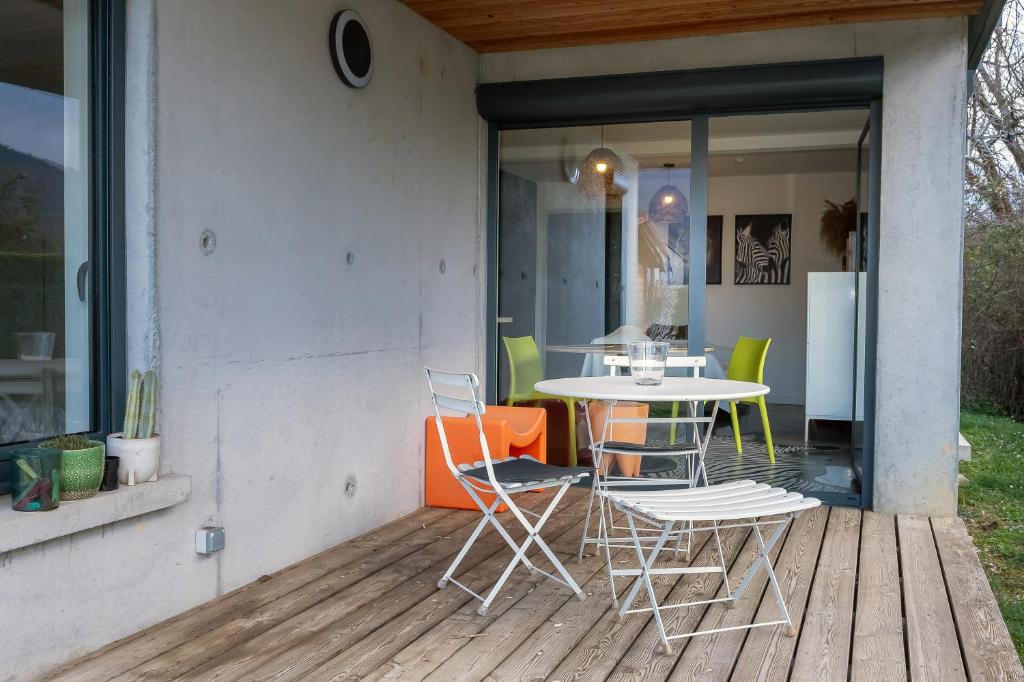 a patio with a table and chairs on a deck at Appart bureau in Le Touvet