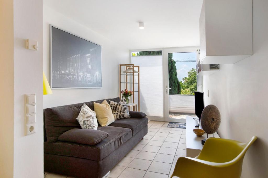 a living room with a brown couch and yellow chairs at Ferienhaus Schwalbennest in Lörrach