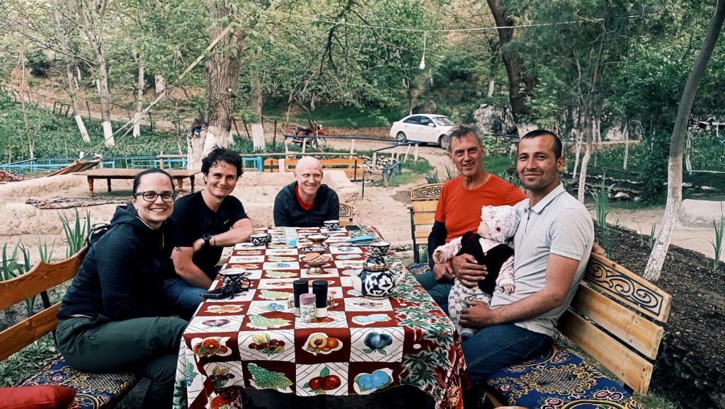 a group of people sitting around a table at Asraf village guesthouse in Aydar Kul’