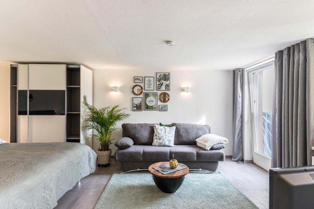 a living room with a bed and a couch at Ferienwohnung Schweizer in Gaienhofen