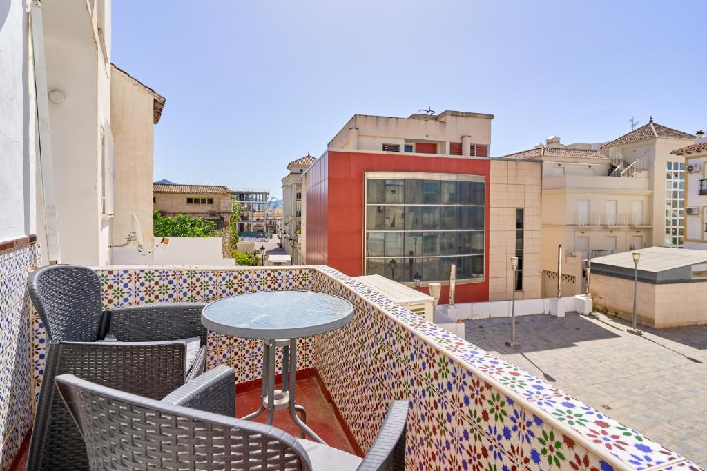 a patio with a table and chairs on a balcony at Vivienda junto a Plaza España in Nerja