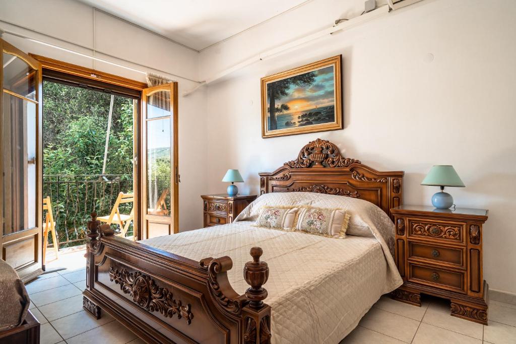 a bedroom with a wooden bed and a window at Makis Apartment Katelios in Khionáta