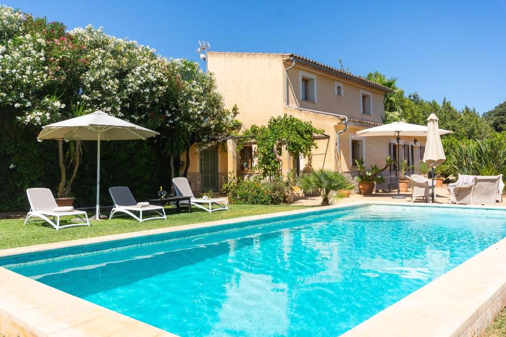 a villa with a swimming pool and a house at Finca Son Fornes in Búger