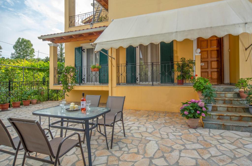 a patio with a table and chairs in front of a house at Kallithea House in Corfu
