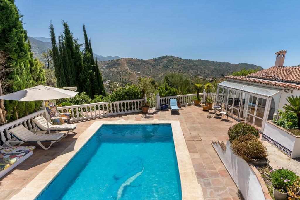 a swimming pool in front of a house at Villa Villena Torrox in Torrox