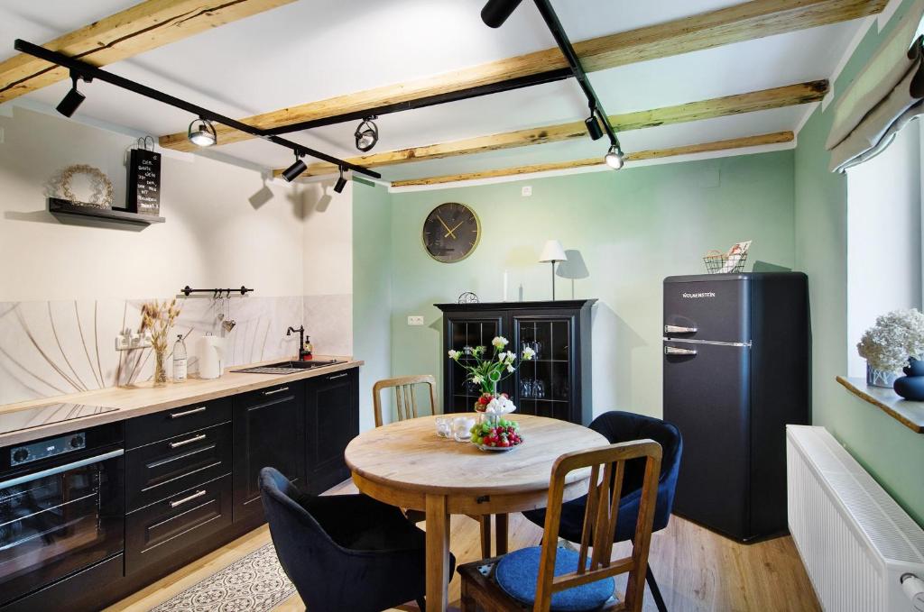 a kitchen with a table with chairs and a refrigerator at Ferienwohnung Seelenruhig in Wollershausen