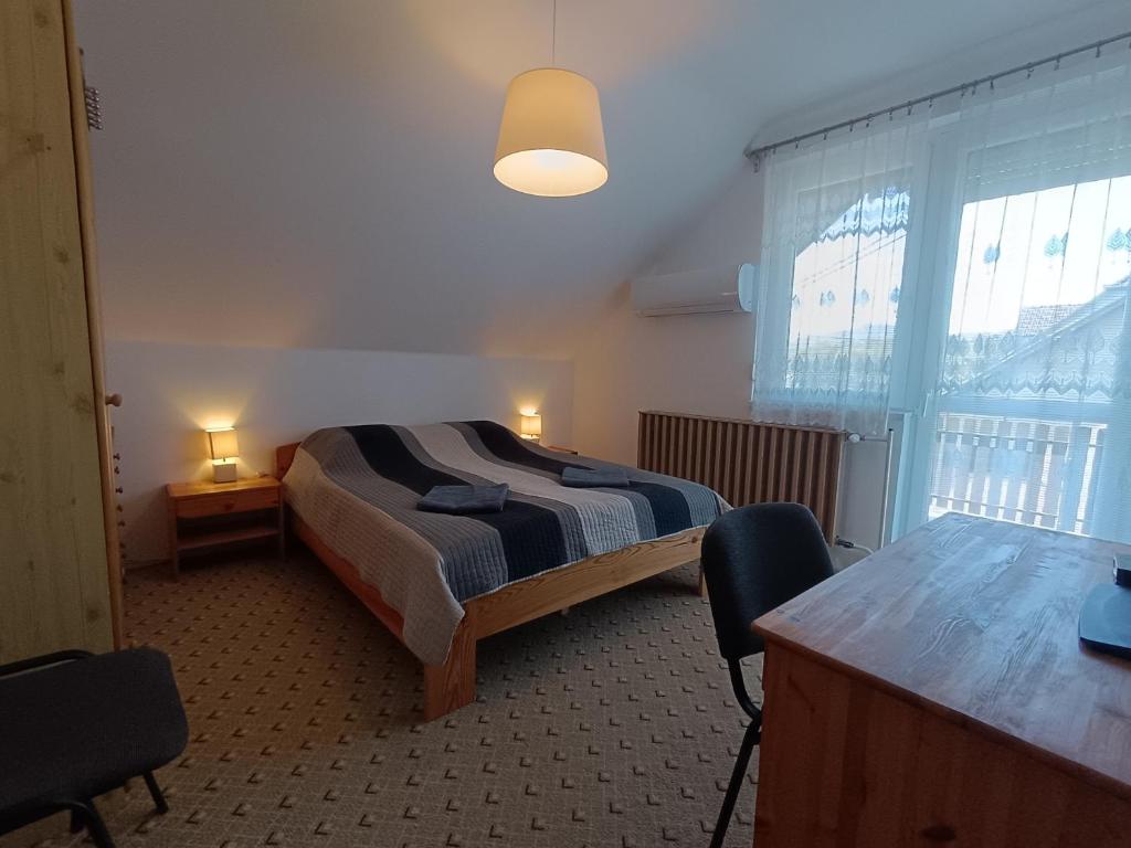 a bedroom with a bed and a table and chairs at Herőke Vendégház in Terény