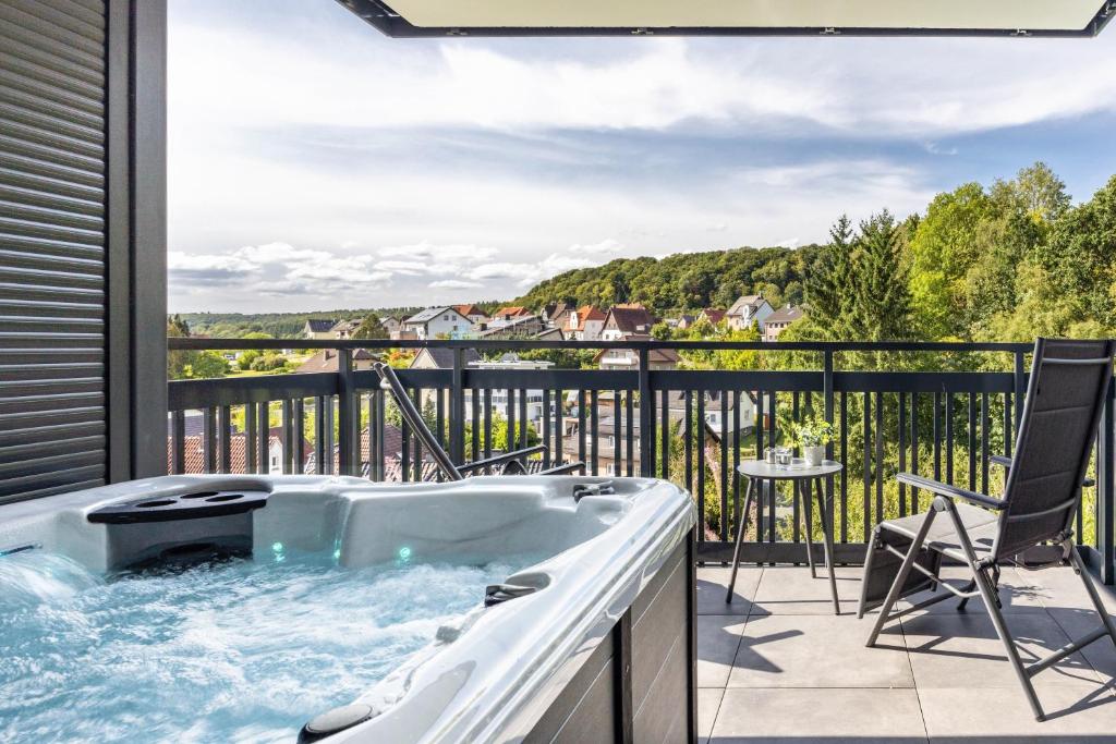 a bath tub on a balcony with a view at Egge Resort 7d mit Whirpool u Sauna in Altenbeken