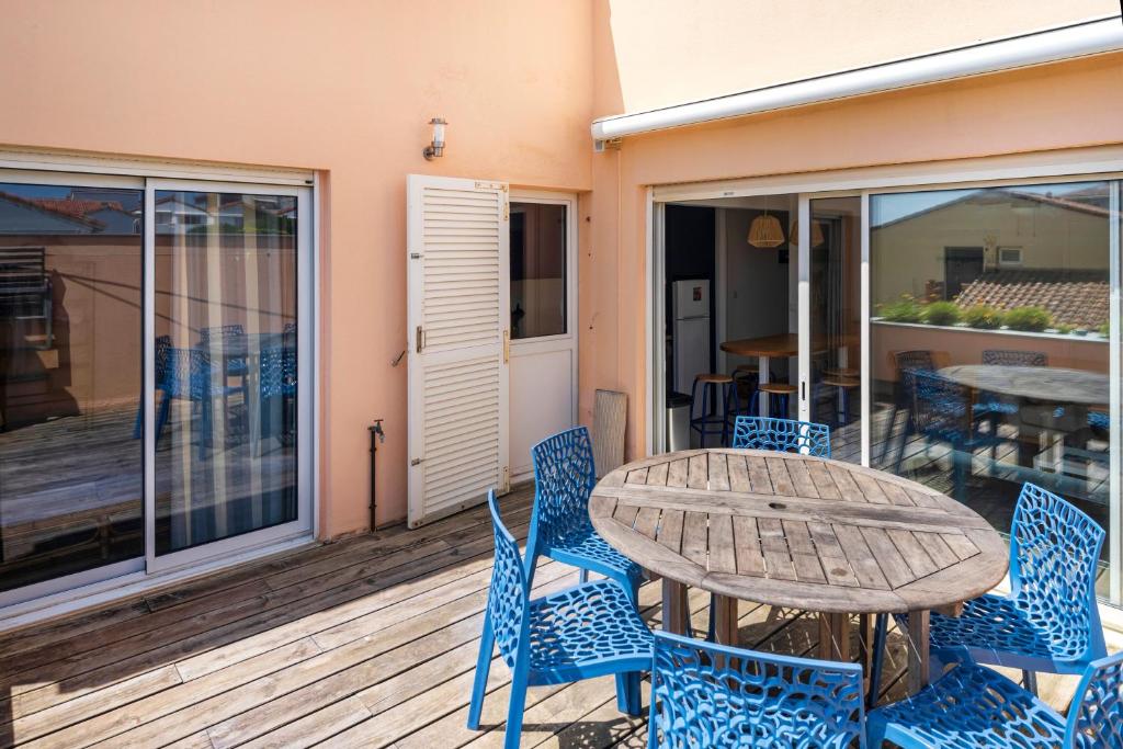 a patio with a table and chairs on a deck at Appartement Notre Dame in Capbreton